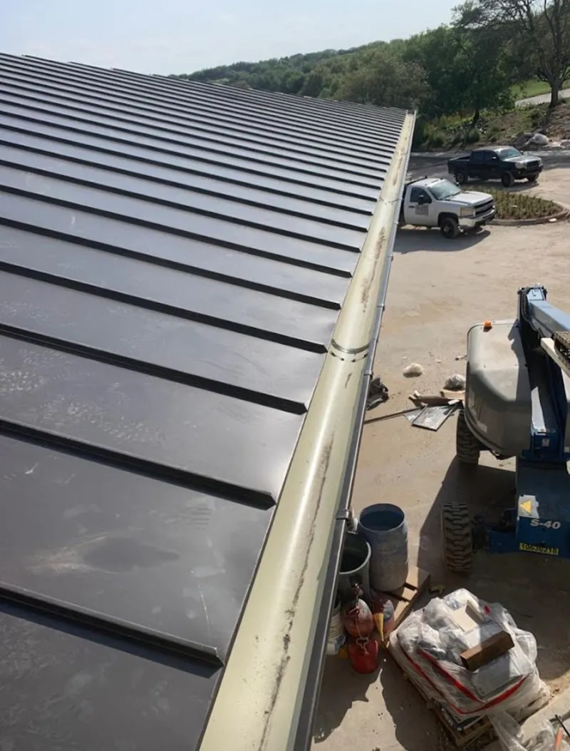 Standing seam panel and gutter detail on a metal roofing jobsite in Plaistow